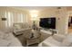 Cozy living room with neutral furniture, a large window for natural light, and a modern entertainment center at 7119 Leighton Way, Orlando, FL 32822
