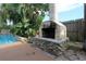 Backyard outdoor fireplace and access to stone waterfall pool feature at 7119 Leighton Way, Orlando, FL 32822