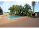 Outdoor pool area with a stone waterfall feature, outdoor fireplace, tropical landscaping, and spacious deck at 7119 Leighton Way, Orlando, FL 32822