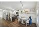 Open-concept living area with modern white kitchen, island, and stylish dining space with wood-look floors at 721 Polo Park Blvd, Davenport, FL 33897