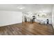 Open-concept living space with wood flooring, white walls, and a modern kitchen for seamless entertaining at 721 Polo Park Blvd, Davenport, FL 33897