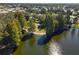 Aerial view of a serene lake with mature trees, creating a relaxing waterfront setting for the community at 721 Polo Park Blvd, Davenport, FL 33897