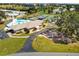 Aerial view of community amenities including pool, tennis courts, landscaping and golf cart parking at 721 Polo Park Blvd, Davenport, FL 33897