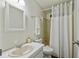 Bright bathroom featuring a white sink, toilet, and shower with white curtain at 721 Polo Park Blvd, Davenport, FL 33897
