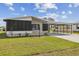 Charming home featuring a screened-in porch and a covered carport, complemented by a well-maintained lawn at 721 Polo Park Blvd, Davenport, FL 33897