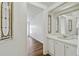Hallway view of bedroom with wood flooring and updated bathroom with mirror at 721 Polo Park Blvd, Davenport, FL 33897