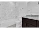 Bathroom with marble tiled shower and bath, dark vanity, and sleek hardware at 773 Marion Oaks Pass, Ocala, FL 34473