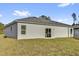 Exterior view featuring a sliding glass door and spacious backyard at 773 Marion Oaks Pass, Ocala, FL 34473