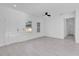 Bright, open-concept living room featuring tile floors, a ceiling fan, and natural light at 773 Marion Oaks Pass, Ocala, FL 34473
