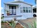 Charming single-story home with blue front door, white railings, and lush landscaping at 9000 Us Highway 192 # 835, Clermont, FL 34714