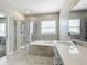 A spacious bathroom featuring a glass shower, soaking tub, and double sinks at 917 Carmillion Ct, Groveland, FL 34736