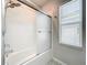 Bathroom featuring a shower-tub combo with glass sliding door at 917 Carmillion Ct, Groveland, FL 34736