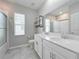 Bathroom with a modern double vanity, shower with glass door, and convenient shelving at 917 Carmillion Ct, Groveland, FL 34736