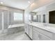 Bright bathroom showcasing a glass shower, soaking tub, double sinks and large mirror at 917 Carmillion Ct, Groveland, FL 34736