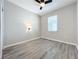 Bedroom with wood-look floors, light fixture and natural light from the window with blinds at 917 Carmillion Ct, Groveland, FL 34736