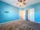 Bedroom with blue accent wall, carpet and a ceiling fan at 917 Carmillion Ct, Groveland, FL 34736
