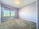 A light purple bedroom with carpet and a window letting in natural light at 917 Carmillion Ct, Groveland, FL 34736