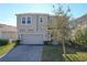 Exterior elevation of home with brick driveway and a two-car garage at 917 Carmillion Ct, Groveland, FL 34736