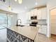 Kitchen island with stylish tile accents, stainless steel appliances, and a view of the screened patio at 917 Carmillion Ct, Groveland, FL 34736