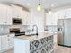 Kitchen boasts decorative tile on island, stainless appliances, and ample cabinet space at 917 Carmillion Ct, Groveland, FL 34736