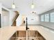 Modern kitchen with island, stainless steel sink, and open view to the staircase at 917 Carmillion Ct, Groveland, FL 34736