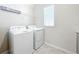 Bright laundry room featuring a washer, dryer, and wire shelving at 917 Carmillion Ct, Groveland, FL 34736