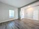 Living room with gray-toned wood floors, a large window for natural light, and neutral paint at 917 Carmillion Ct, Groveland, FL 34736
