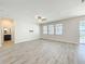 Bright living room with wood-look floors, ceiling fan, tv mount and backyard patio access at 917 Carmillion Ct, Groveland, FL 34736