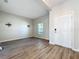 Living room with wood-look floors, tv mount, and a white front door at 917 Carmillion Ct, Groveland, FL 34736