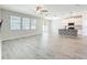 Open living room connected to the kitchen, featuring gray floors, fan, and natural light at 917 Carmillion Ct, Groveland, FL 34736