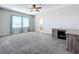 A spacious bedroom with a ceiling fan, carpet floors, and large windows for ample light at 917 Carmillion Ct, Groveland, FL 34736