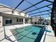 An inviting screened-in pool surrounded by a patio and an outdoor seating area at 917 Carmillion Ct, Groveland, FL 34736
