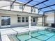 A screened-in pool with blue tiled trim, and an outdoor patio area at 917 Carmillion Ct, Groveland, FL 34736