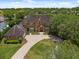 Aerial view of the brick house with a circular driveway and manicured landscaping at 9501 Tavistock Rd, Orlando, FL 32827