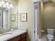 Charming bathroom featuring granite counters, framed mirror, wallpaper, and a convenient shower with tiled walls at 9501 Tavistock Rd, Orlando, FL 32827