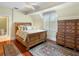 Cozy bedroom with wood floors, ornate dresser, area rugs, and natural light, creating a relaxing atmosphere at 9501 Tavistock Rd, Orlando, FL 32827