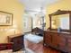 Beautiful bedroom showcasing a four-poster bed, wooden floors, and antique dresser with a large mirror at 9501 Tavistock Rd, Orlando, FL 32827