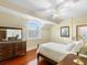 Well-lit bedroom with wood floors, decorative pillows, arched window, and neutral walls, offering a tranquil space at 9501 Tavistock Rd, Orlando, FL 32827