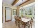 Charming dining area with wooden table, chairs, and bright windows overlooking the landscaped backyard at 9501 Tavistock Rd, Orlando, FL 32827