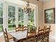 Charming dining room featuring a large window overlooking the lush backyard and classic chandelier at 9501 Tavistock Rd, Orlando, FL 32827