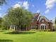 Large brick home with a spacious lawn and mature trees at 9501 Tavistock Rd, Orlando, FL 32827
