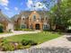 Charming two-story brick home with manicured lawn, complemented by colorful flower beds at 9501 Tavistock Rd, Orlando, FL 32827