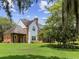 Stunning home exterior featuring brick accents, manicured lawn, and mature trees, offering a serene and private setting at 9501 Tavistock Rd, Orlando, FL 32827