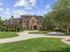A charming two-story brick home features a beautifully landscaped front yard and a curved driveway at 9501 Tavistock Rd, Orlando, FL 32827