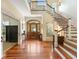 Grand foyer features hardwood floors, staircase with iron railing, and a wood front door with glass at 9501 Tavistock Rd, Orlando, FL 32827