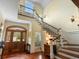 Stunning foyer with hardwood floors, elegant staircase, and a grand entryway with wood door at 9501 Tavistock Rd, Orlando, FL 32827