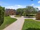 Expansive front yard featuring a circular driveway, lush landscaping, and a beautiful brick home at 9501 Tavistock Rd, Orlando, FL 32827