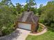 Aerial view of brick garage with a driveway, surrounded by lush landscaping at 9501 Tavistock Rd, Orlando, FL 32827