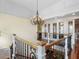 Elegant hallway with wrought iron railings, hardwood floors, and a chandelier, showcasing sophisticated architectural details at 9501 Tavistock Rd, Orlando, FL 32827