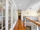 Bright hallway boasts hardwood floors, glass-paneled doors, and decorative wall sconces at 9501 Tavistock Rd, Orlando, FL 32827